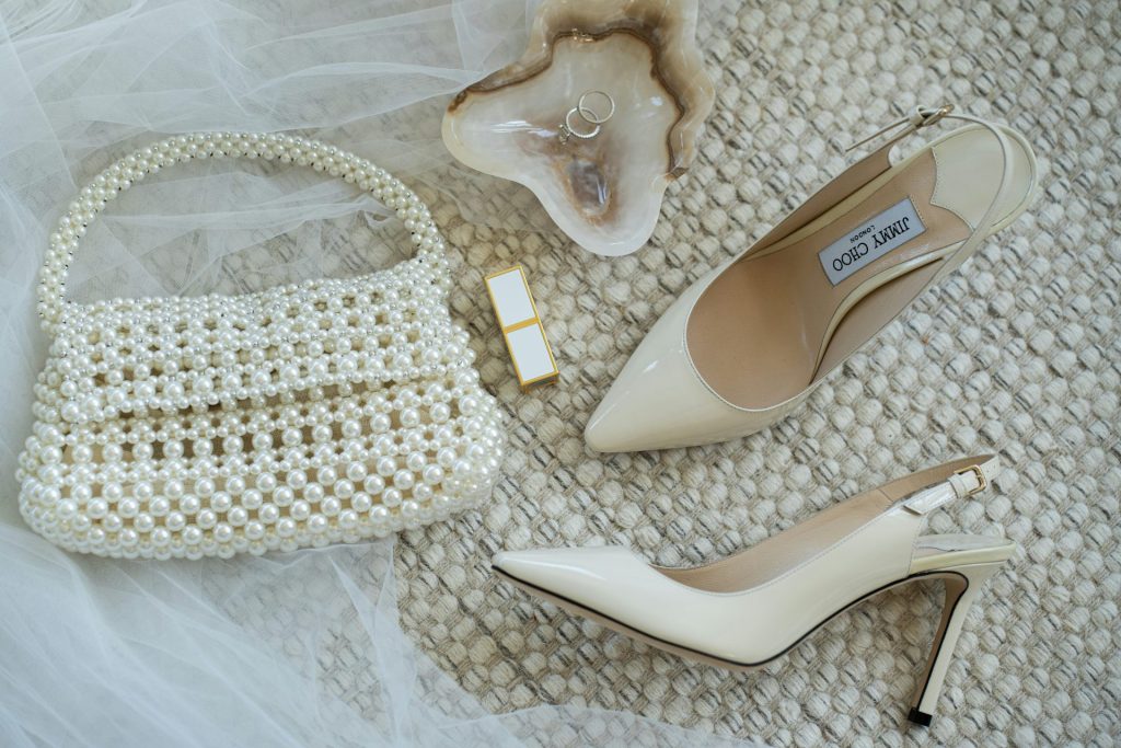 A pair of shoes and a purse on a bed